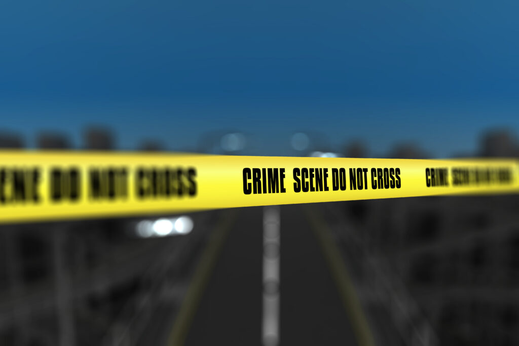 3D police line tape against defocussed city background