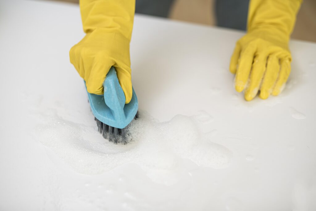 high-angle-woman-with-cleaning-gloves-using-brush